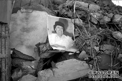 在兹利坦附近，卡扎菲的画像掉落在被轰炸后的废墟上。图/人民图片
