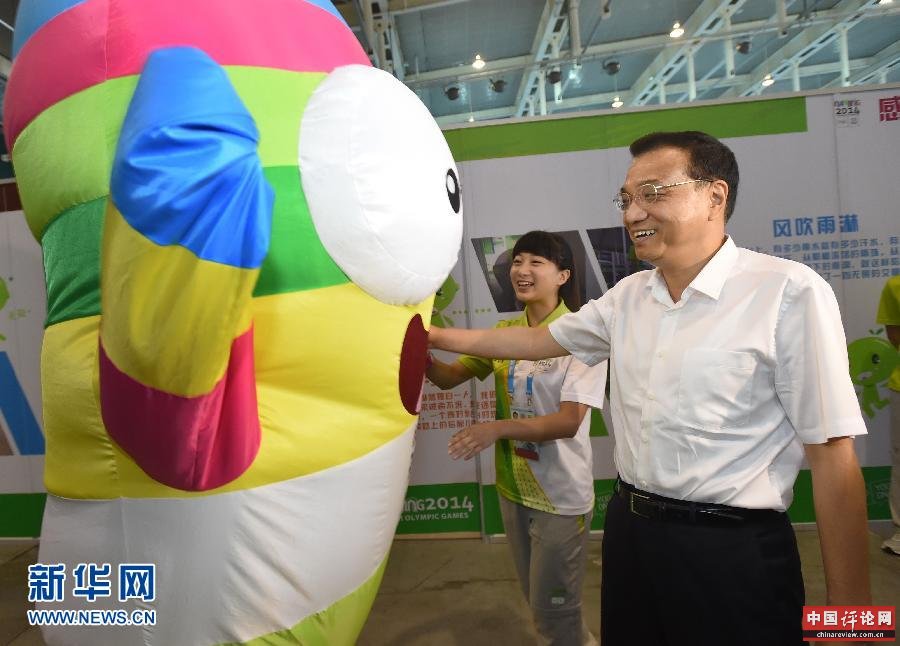这是一名扮成青奥会吉祥物“砳砳”的志愿者表演后，李克强称赞他充满青春的活力。新华社记者马占成摄