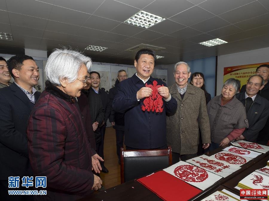 这是15日上午，习近平在西安市雁塔区电子城街道二〇五所社区服务中心，拿起一幅“三阳开泰”剪纸，祝愿全国各族人民新春愉快、羊年大吉，生活喜气洋洋，事业蒸蒸日上。新华社记者 李学仁 摄 