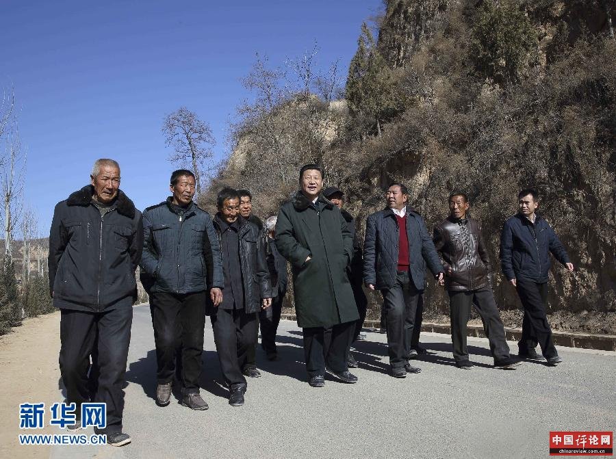 这是13日上午，习近平在延安市延川县文安驿镇梁家河村调研时同村民边走边聊。新华社记者 兰红光 摄 