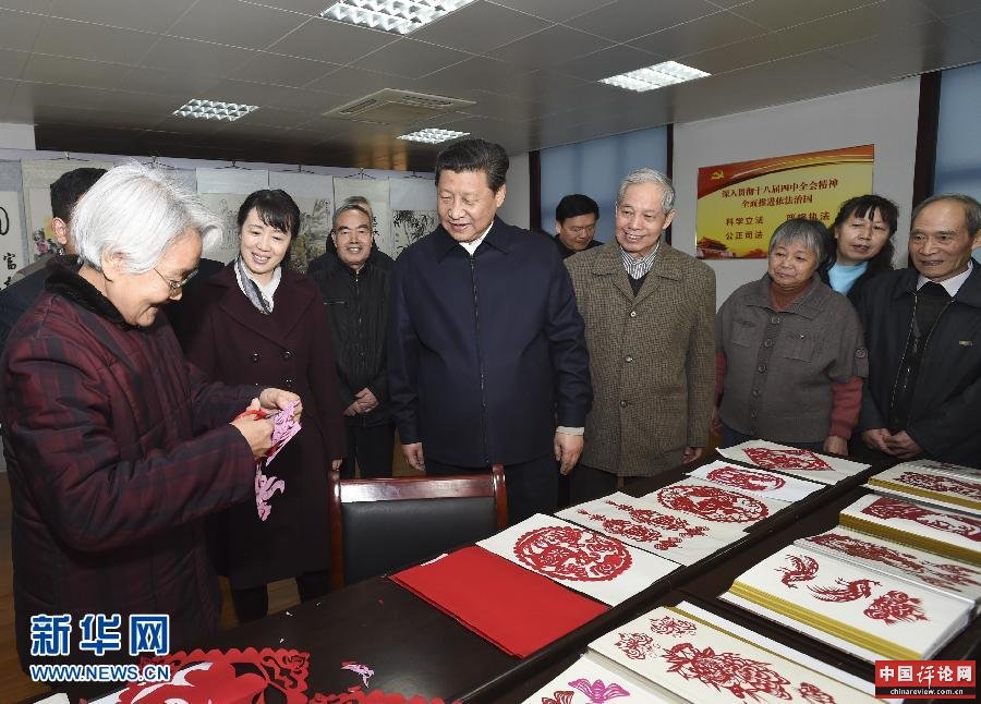 这是15日上午，习近平在西安市雁塔区电子城街道二〇五所社区服务中心观看社区居民的剪纸艺术。新华社记者 李学仁 摄 