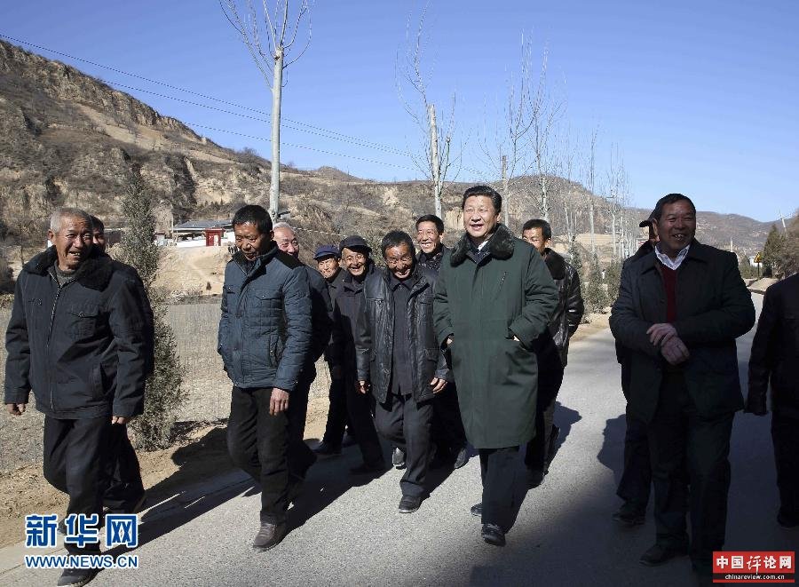 这是13日上午，习近平在延安市延川县文安驿镇梁家河村调研时同村民边走边聊。新华社记者 兰红光 摄 
