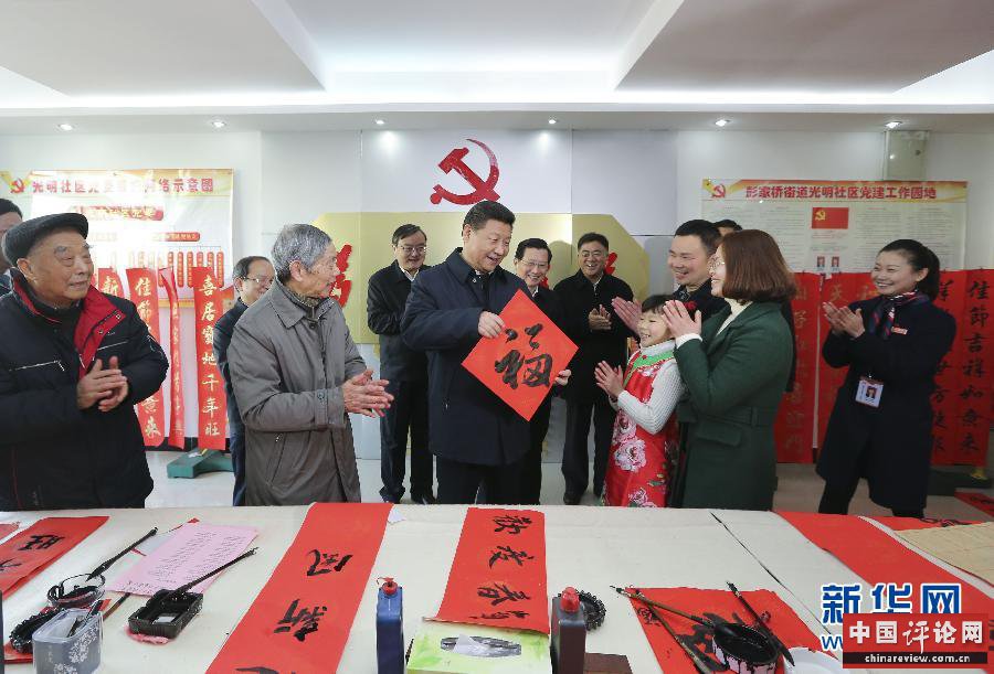 这是2月3日，习近平在南昌市东湖区彭家桥街道光明社区书画室，接过一位小朋友现场书写的 “福”字，祝大家都幸福。 新华社记者兰红光摄